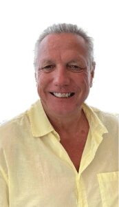 A man with white hair and a yellow shirt.