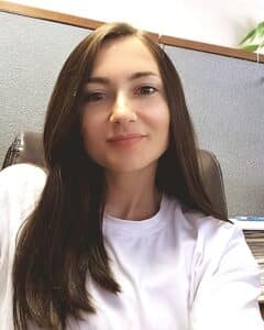 A woman with long hair sitting in an office chair.